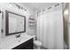 Well-lit bathroom features a vanity sink with a large framed mirror and shower with white curtain at 2767 Nw Magnolia Creek Dr, Kennesaw, GA 30152