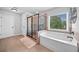 Bright primary bathroom features a soaking tub, stand up shower, and a large window at 2767 Nw Magnolia Creek Dr, Kennesaw, GA 30152