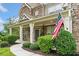 Charming home with a stone facade, covered porch adorned with an American flag, and lush landscaping, exuding curb appeal at 2767 Nw Magnolia Creek Dr, Kennesaw, GA 30152