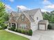 A beautiful house with stone accents and a 3-car garage is set on a well-maintained green lawn at 2767 Nw Magnolia Creek Dr, Kennesaw, GA 30152