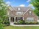 Charming home featuring a stone facade, covered porch, manicured landscaping, and an American flag at 2767 Nw Magnolia Creek Dr, Kennesaw, GA 30152