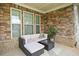 Inviting front porch with stone accents, comfortable seating, and stylish decor, perfect for relaxing and enjoying the outdoors at 2767 Nw Magnolia Creek Dr, Kennesaw, GA 30152