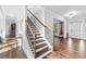 Wooden staircase with dark wood treads, white risers, and an iron and wood railing at 2767 Nw Magnolia Creek Dr, Kennesaw, GA 30152