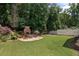 Large backyard featuring waterfall, fireplace, patio, and playset in a lush, green setting at 2941 Elizabeth Se St, Smyrna, GA 30080