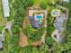Expansive aerial view of a luxurious estate with a pool, lush landscaping, and a long private driveway at 150 Henderson Farm Dr, Woodstock, GA 30188
