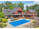 Aerial view of backyard featuring in-ground pool and a large home surrounded by mature trees at 150 Henderson Farm Dr, Woodstock, GA 30188