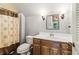 Traditional bathroom with a framed mirror, wood vanity, and shower with a brown patterned curtain at 150 Henderson Farm Dr, Woodstock, GA 30188