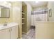 Well-lit bathroom featuring a single sink, a large framed mirror, and a shower with a curtain at 150 Henderson Farm Dr, Woodstock, GA 30188