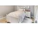 Comfortable bedroom with floral bedding, a white wooden bedframe and a bedside table at 150 Henderson Farm Dr, Woodstock, GA 30188