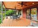 Covered deck with wooden ceilings, ceiling fans, outdoor furniture, and lush greenery at 150 Henderson Farm Dr, Woodstock, GA 30188