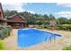 Inviting backyard pool features a stone fireplace, mature landscaping, and a serene outdoor living space at 150 Henderson Farm Dr, Woodstock, GA 30188