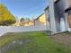 Backyard view of gray home with boarded-up windows, fire damage, and a white vinyl fence at 1980 Piedmont Pointe Dr, Lithonia, GA 30058