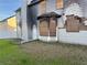 Backyard view of gray home with boarded-up windows, fire damage, and a white door at 1980 Piedmont Pointe Dr, Lithonia, GA 30058