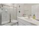 Bright bathroom featuring a glass shower, white marbled tile surround, and white vanity with modern hardware at 2501 Painted Buckeye Chase Se, Smyrna, GA 30080