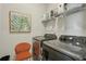 A modern laundry room with gray front load washer and dryer, wire rack shelving, and decorative foliage print at 2501 Painted Buckeye Chase Se, Smyrna, GA 30080