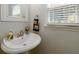 Well-lit half bath featuring a pedestal sink and decorative fixtures at 1670 Burnt Oak Way, Dacula, GA 30019