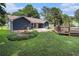 Backyard with a pool and patio area, green lawn, garden, and dark siding on the home at 50 Blackberry Lane, Covington, GA 30016