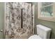 Bathroom with a shower and decorative shower curtain, plus a toilet, window and beige colored walls at 50 Blackberry Lane, Covington, GA 30016