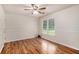 Bedroom with hardwood flooring, a ceiling fan, and a large window with view of the front yard at 50 Blackberry Lane, Covington, GA 30016