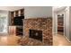 Bright living room featuring a brick fireplace, built-in shelving, and wood floors at 50 Blackberry Lane, Covington, GA 30016