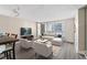 Living room featuring a grey sofa, white chairs, dining table, and hardwood style floors at 620 Peachtree Ne St # 911, Atlanta, GA 30308