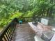 Wooden deck surrounded by trees featuring an outdoor rug and forest backdrop at 8959 Stonebridge Blvd, Douglasville, GA 30134