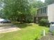 Street view of a townhome community, showing well-maintained lawns and convenient parking. Large trees provide shade at 8959 Stonebridge Blvd, Douglasville, GA 30134