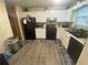 Functional kitchen featuring white cabinets, black appliances, and wood-look flooring. Good counter space is featured at 8959 Stonebridge Blvd, Douglasville, GA 30134