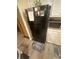 View of a kitchen featuring a black refrigerator and microwave, white cabinets, and modern flooring at 8959 Stonebridge Blvd, Douglasville, GA 30134