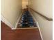 Staircase with carpet runners and wooden handrail descending to lower level at 8959 Stonebridge Blvd, Douglasville, GA 30134