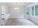Bright dining area with large windows, stylish chandelier, and modern flooring, adjacent to the kitchen at 1333 Trailwater Chase Nw, Acworth, GA 30102