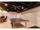 Finished basement featuring a ping pong table, desk, and exposed ceiling at 1361 Chatley Way, Woodstock, GA 30188