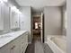 Bathroom featuring vanity, soaking tub, and open doorway to main bedroom at 1361 Chatley Way, Woodstock, GA 30188