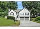 Charming two-story home with a well-manicured lawn, gray trim, and an attached two-car garage at 1361 Chatley Way, Woodstock, GA 30188