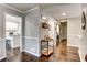 Hallway with hardwood floors, elegant trim, and a convenient bar area adjacent to kitchen at 1361 Chatley Way, Woodstock, GA 30188