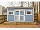 Outbuilding in backyard with double doors, two windows, and fresh paint at 1361 Chatley Way, Woodstock, GA 30188