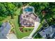 Overhead view of the property featuring a manicured lawn, mature landscaping, and a paved driveway at 3217 Aberrone Pl, Buford, GA 30519