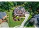 Aerial shot of a brick home, revealing a backyard pool, mature trees, and manicured lawns at 3217 Aberrone Pl, Buford, GA 30519