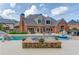 View of the brick exterior featuring large windows and a covered patio overlooking the pool at 3217 Aberrone Pl, Buford, GA 30519