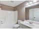 Bathroom with shower-tub combo, white sink, and brushed nickel hardware at 3217 Aberrone Pl, Buford, GA 30519