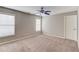 Neutral bedroom with plush carpet, ceiling fan, and sunlit windows at 3217 Aberrone Pl, Buford, GA 30519