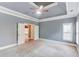 This carpeted bedroom offers lots of natural light and a tray ceiling with a ceiling fan at 3217 Aberrone Pl, Buford, GA 30519