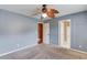 Neutral-toned bedroom featuring a ceiling fan and access to a bathroom at 3217 Aberrone Pl, Buford, GA 30519