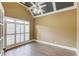 Bedroom with dark ceiling trim, ceiling fan, and natural light from the large shuttered windows at 3217 Aberrone Pl, Buford, GA 30519