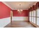 Formal dining room with chandelier, wainscoting and large window with custom curtains at 3217 Aberrone Pl, Buford, GA 30519