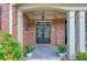 Elegant front entrance with black double doors, white columns, and decorative plants flanking the walkway at 3217 Aberrone Pl, Buford, GA 30519