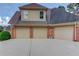 Spacious three-car garage with brick siding and ample parking space on a concrete driveway at 3217 Aberrone Pl, Buford, GA 30519