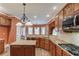 Open concept kitchen with granite countertops, wood cabinets, and stainless steel appliances at 3217 Aberrone Pl, Buford, GA 30519