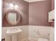 Charming powder room featuring wainscoting, a pedestal sink, and an oval mirror at 3217 Aberrone Pl, Buford, GA 30519
