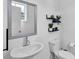 Cozy powder room featuring a modern sink, toilet, decorative shelves, and mirror at 3508 Mount Blue Ave, Tucker, GA 30084